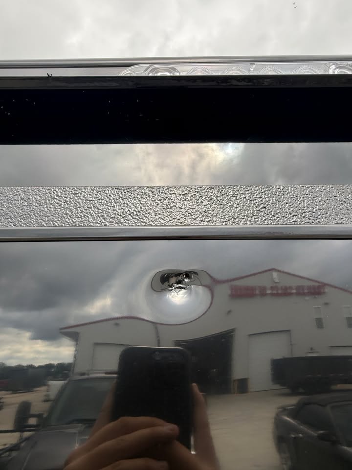 Close-up of the exterior hardware on a black Impact 60 x 8 enclosed cargo trailer