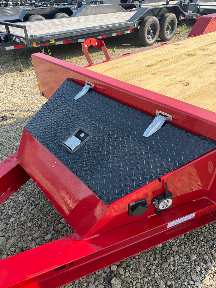 Close-up of the front toolbox on a red Load Trail 83 in x 22 ft full fender tilt trailer